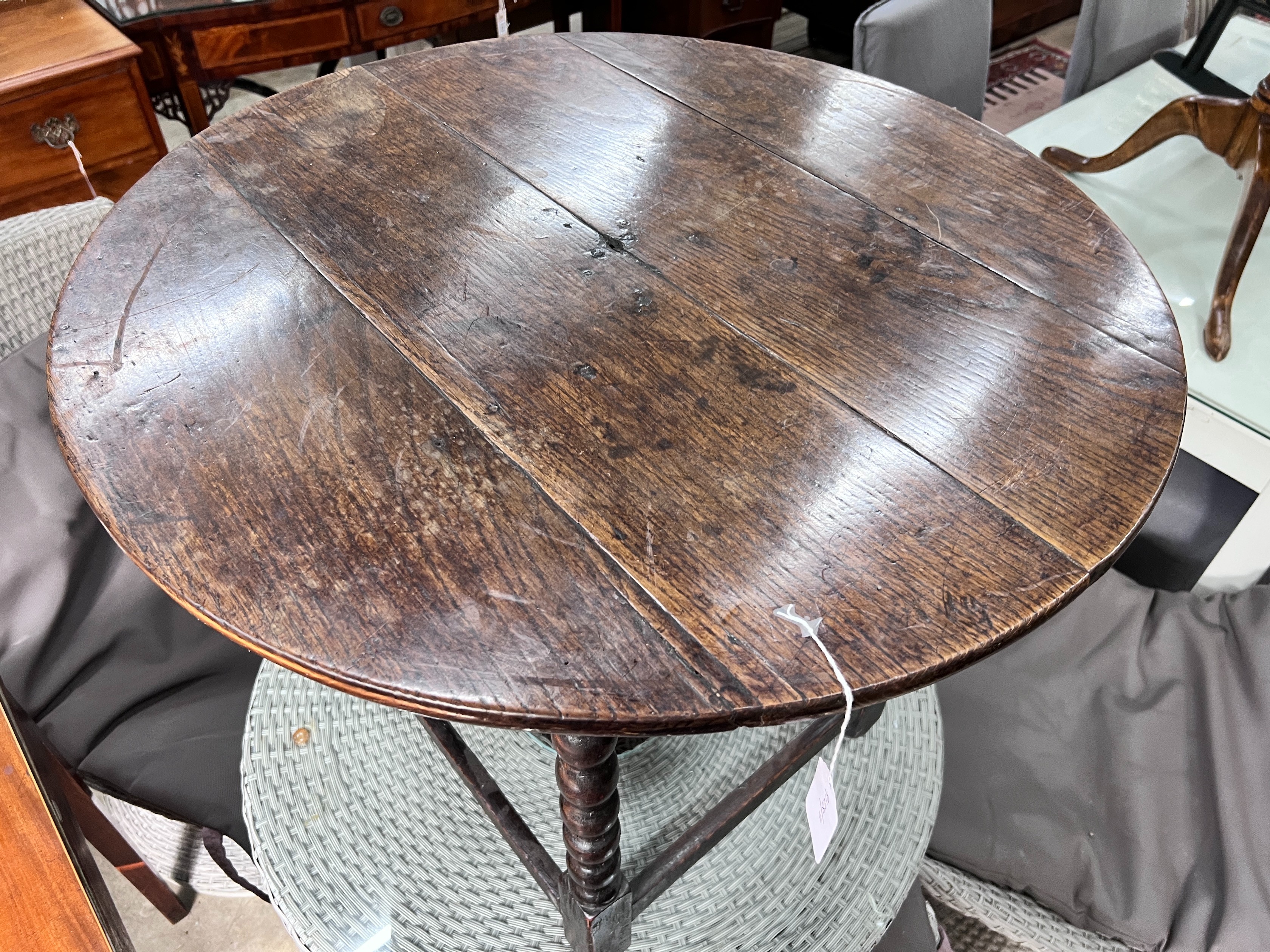 A circular oak bobbin legged table, diameter 73cm, height 61cm *Please note the sale commences at 9am.